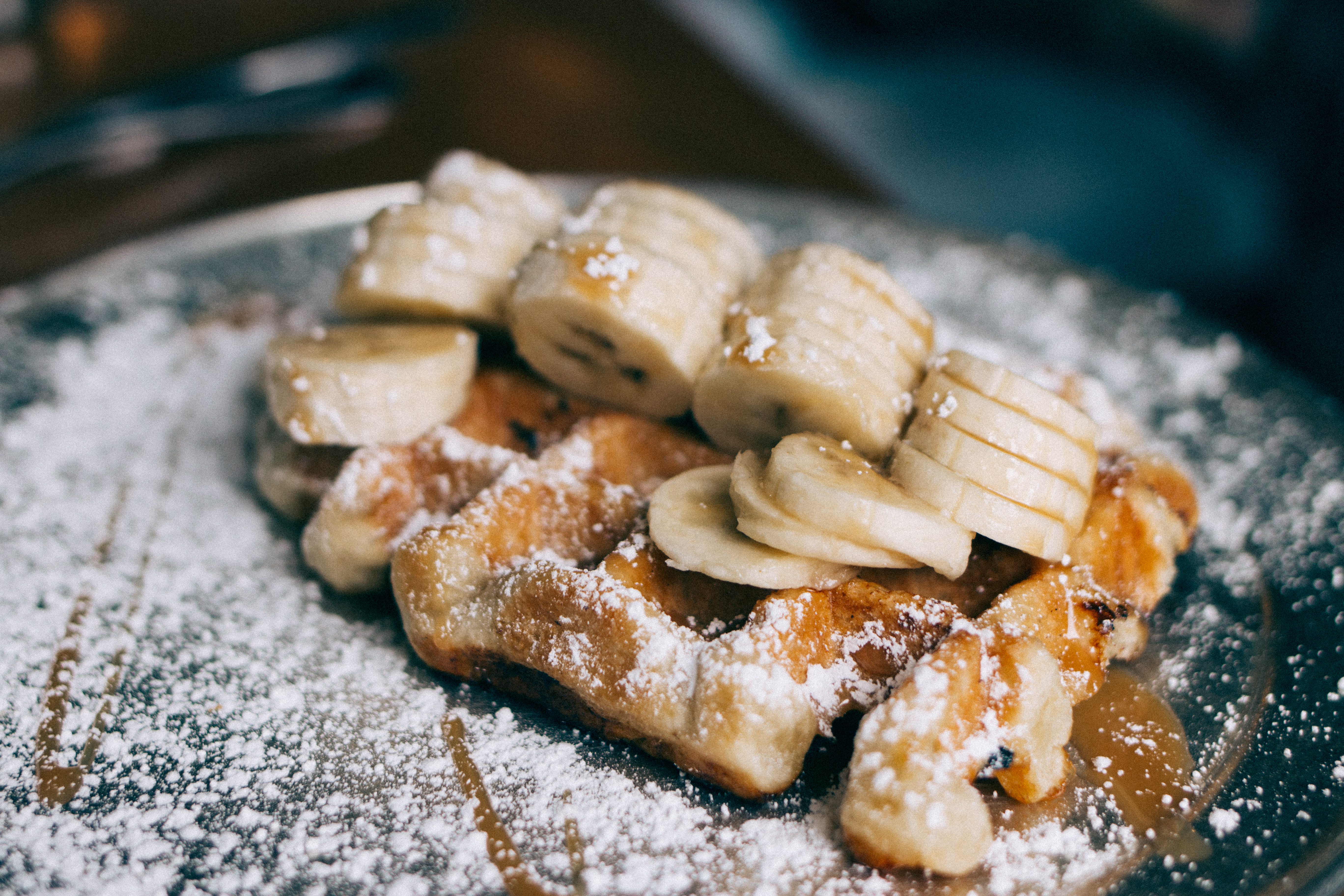Bananas on top of a waffel dusted with powdered sugar