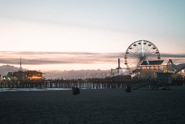 A boardwalk pier with a giant ferriswheel